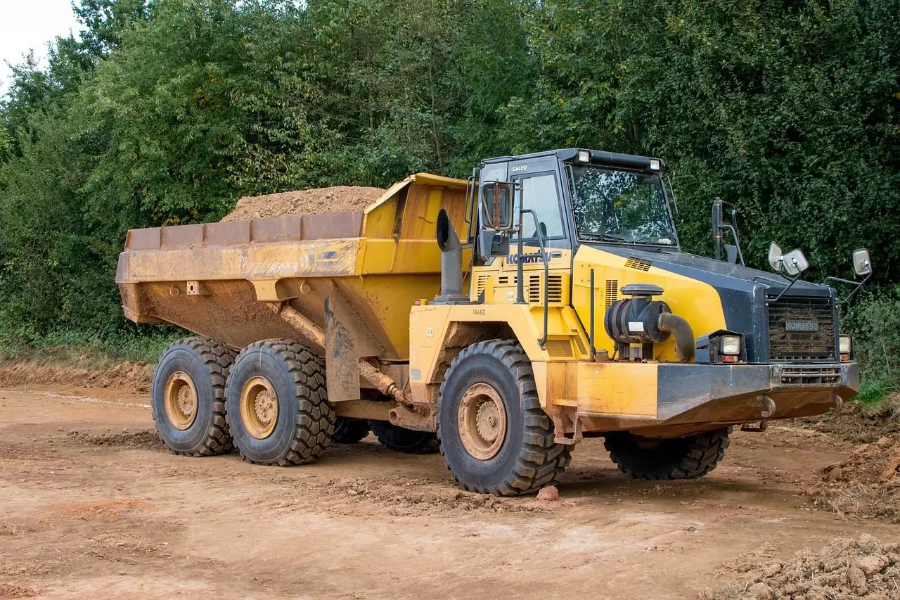 Yellow articulated dump truck loaded with dirt on a work site